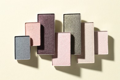 Photo of Beautiful eyeshadow refill pans on beige background, flat lay