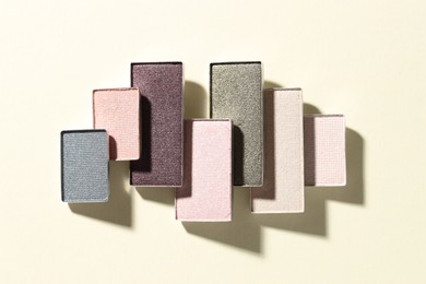 Photo of Beautiful eyeshadow refill pans on beige background, flat lay