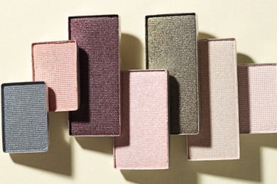 Photo of Beautiful eyeshadow refill pans on beige background, flat lay