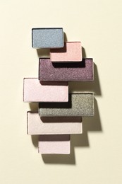 Photo of Beautiful eyeshadow refill pans on beige background, flat lay