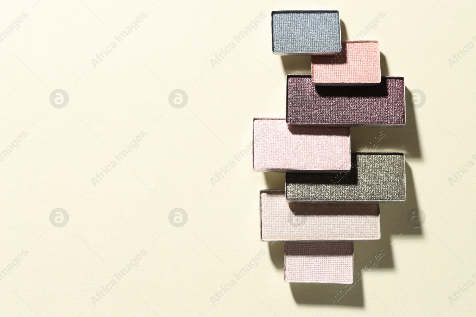 Beautiful eyeshadow refill pans on beige background, flat lay. Space for text Photo of Beautiful eyeshadow refill pans on beige background, flat lay. Space for text