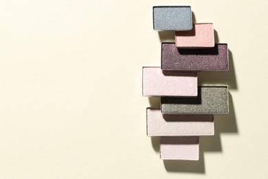 Photo of Beautiful eyeshadow refill pans on beige background, flat lay. Space for text