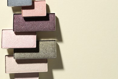 Photo of Beautiful eyeshadow refill pans on beige background, flat lay. Space for text