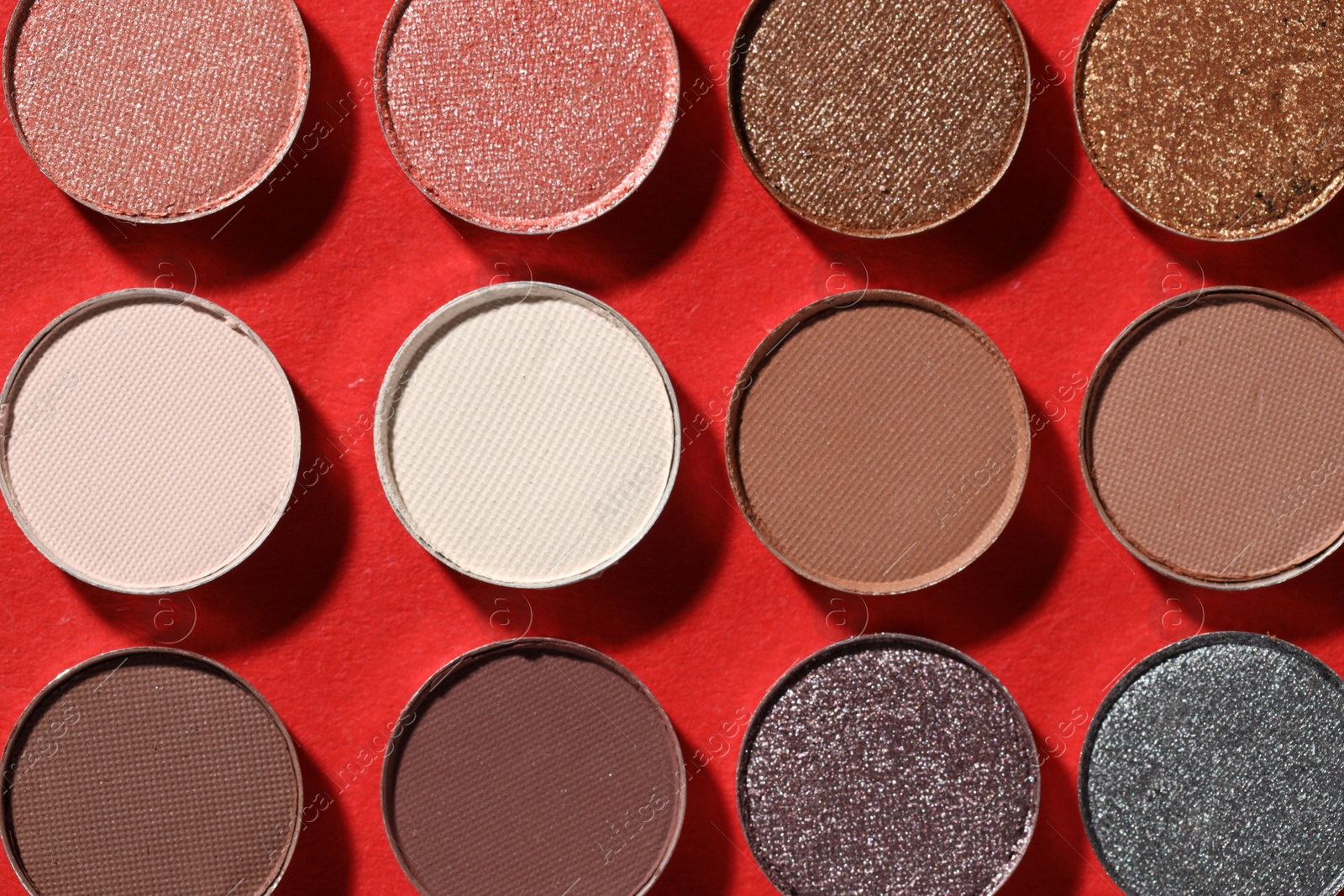 Beautiful eyeshadow refill pans on red background, flat lay Photo of Beautiful eyeshadow refill pans on red background, flat lay