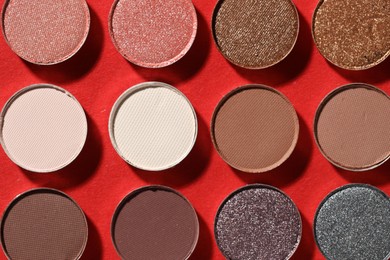 Photo of Beautiful eyeshadow refill pans on red background, flat lay