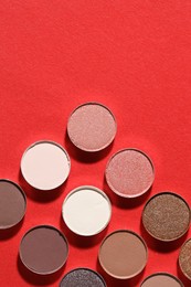 Photo of Beautiful eyeshadow refill pans on red background, flat lay. Space for text