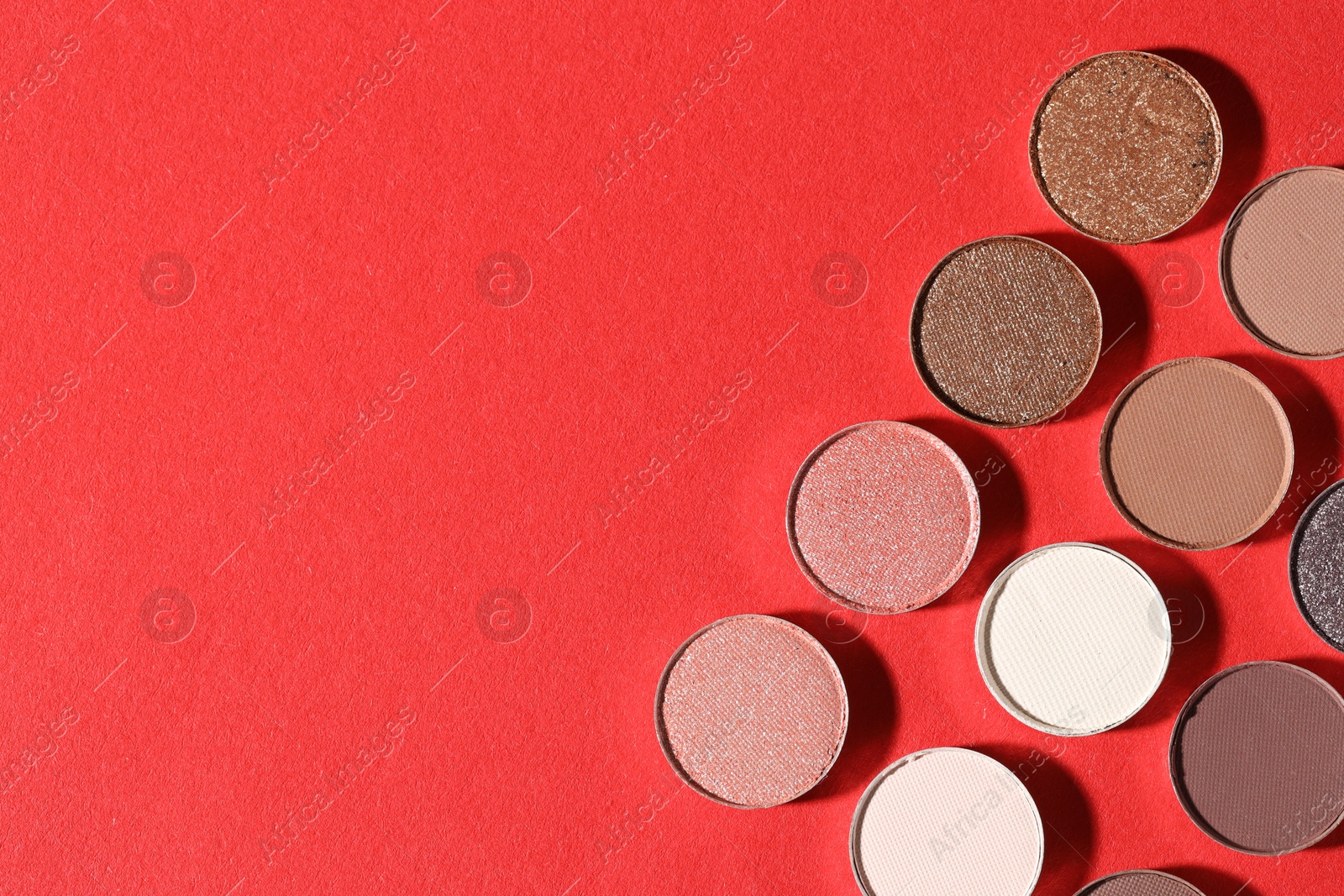 Beautiful eyeshadow refill pans on red background, flat lay. Space for text Photo of Beautiful eyeshadow refill pans on red background, flat lay. Space for text