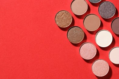 Photo of Beautiful eyeshadow refill pans on red background, flat lay. Space for text