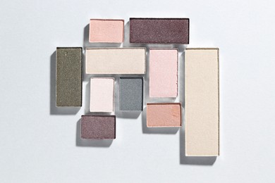 Photo of Beautiful eyeshadow refill pans on light background, flat lay