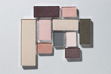 Photo of Beautiful eyeshadow refill pans on light background, flat lay