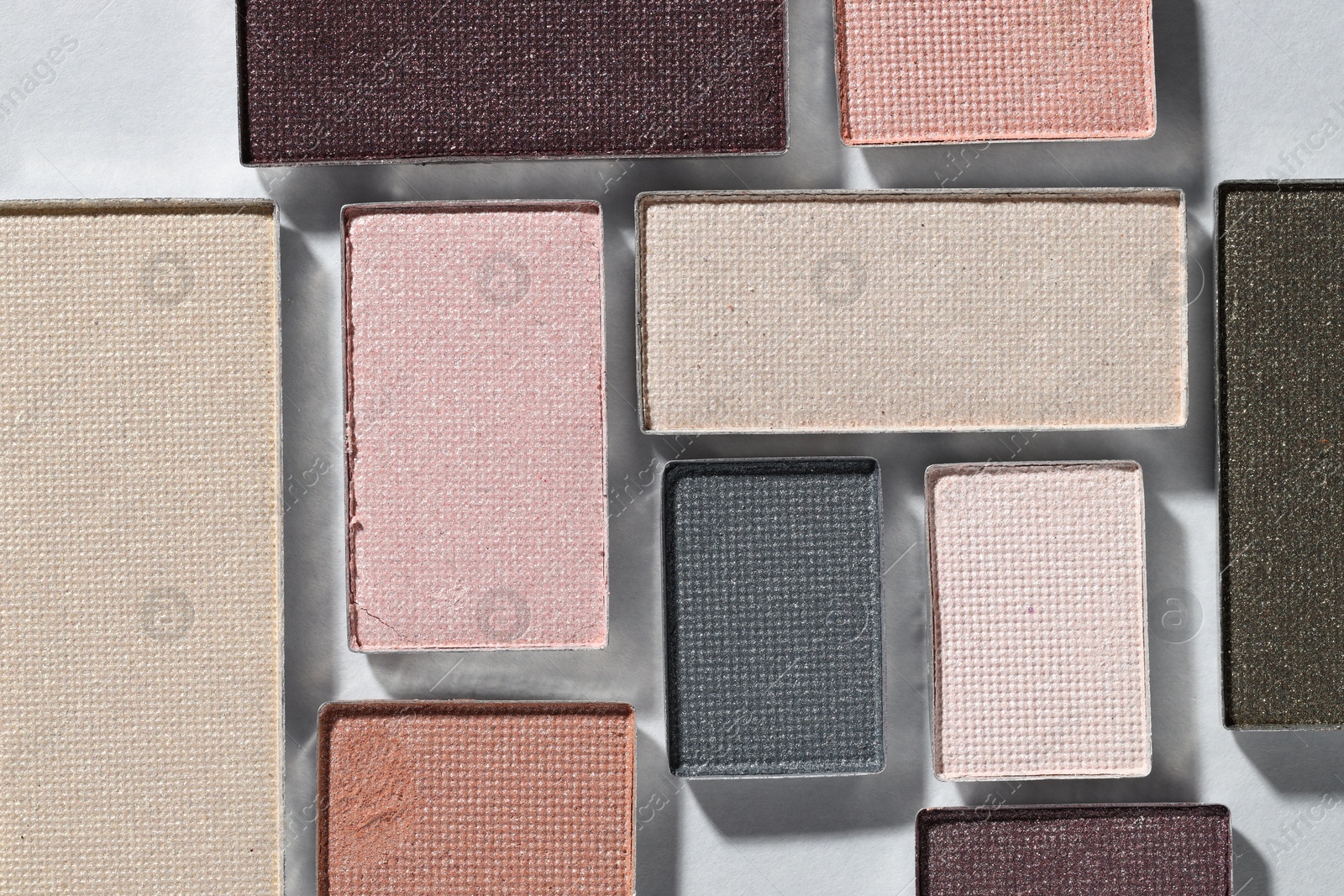 Beautiful eyeshadow refill pans on light background, flat lay Photo of Beautiful eyeshadow refill pans on light background, flat lay