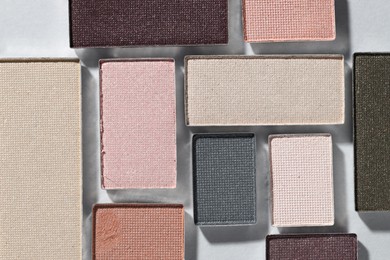 Photo of Beautiful eyeshadow refill pans on light background, flat lay