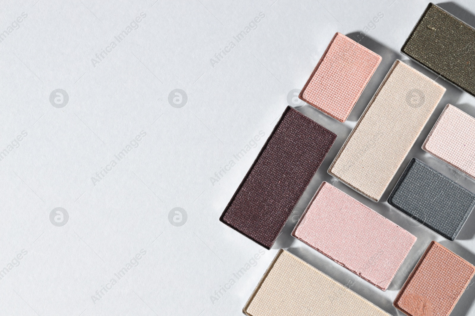 Beautiful eyeshadow refill pans on light background, flat lay. Space for text Photo of Beautiful eyeshadow refill pans on light background, flat lay. Space for text