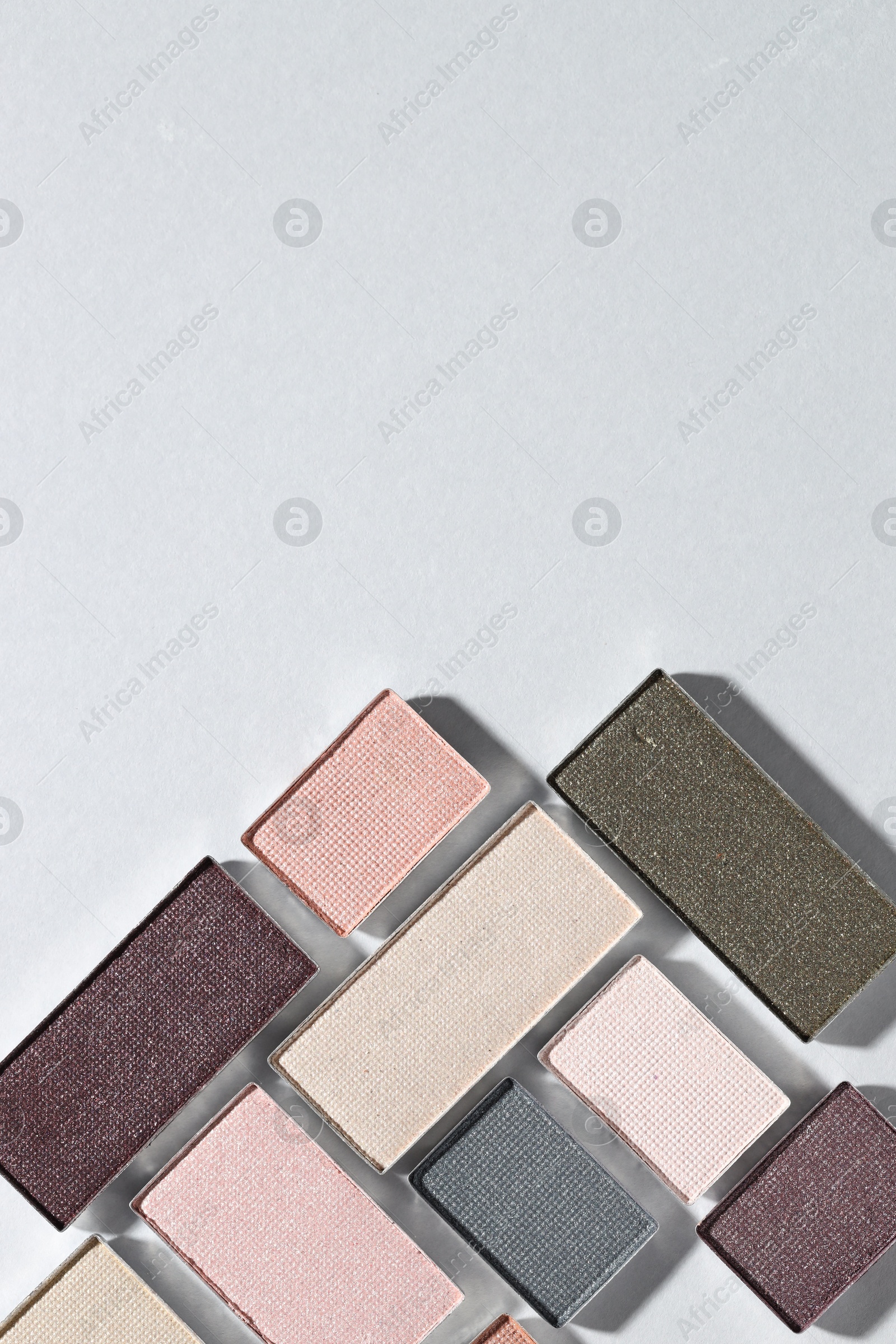 Beautiful eyeshadow refill pans on light background, flat lay. Space for text Photo of Beautiful eyeshadow refill pans on light background, flat lay. Space for text