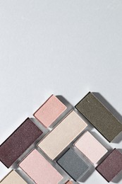 Photo of Beautiful eyeshadow refill pans on light background, flat lay. Space for text