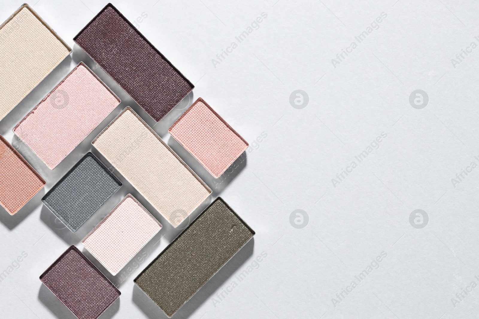 Beautiful eyeshadow refill pans on light background, flat lay. Space for text Photo of Beautiful eyeshadow refill pans on light background, flat lay. Space for text