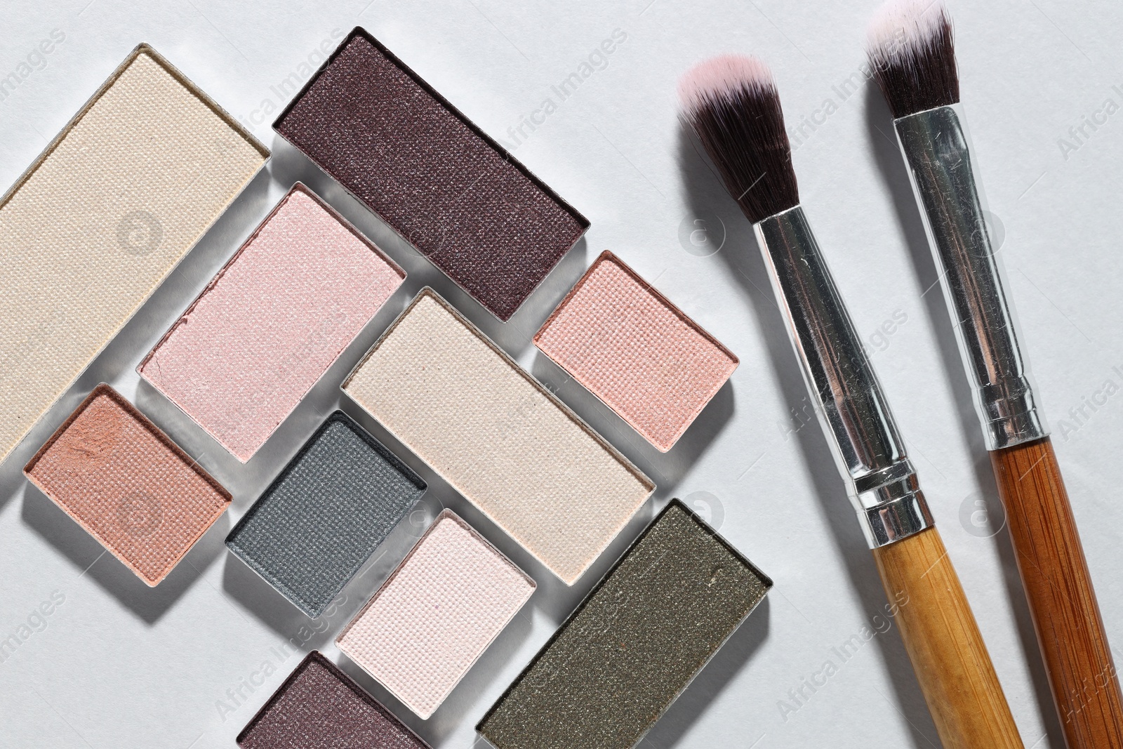 Beautiful eyeshadow refill pans and brushes on light background, flat lay Photo of Beautiful eyeshadow refill pans and brushes on light background, flat lay