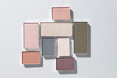 Photo of Beautiful eyeshadow refill pans on light background, flat lay