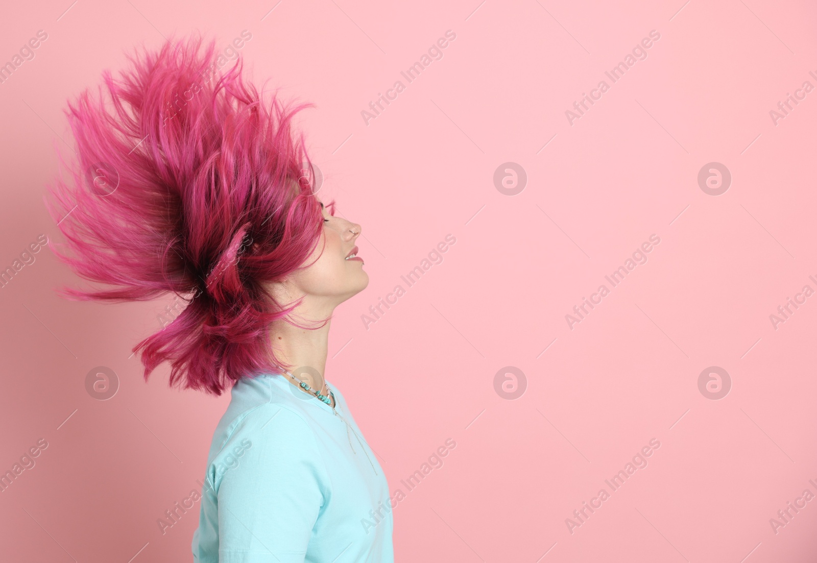 Beautiful woman with bright dyed hair shaking head on pink background, space for text Photo of Beautiful woman with bright dyed hair shaking head on pink background, space for text