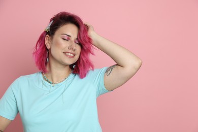 Photo of Beautiful woman with bright dyed hair on pink background