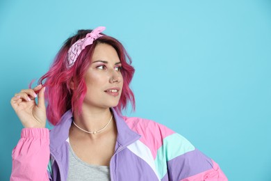 Photo of Beautiful woman with pink dyed hair on light blue background, space for text