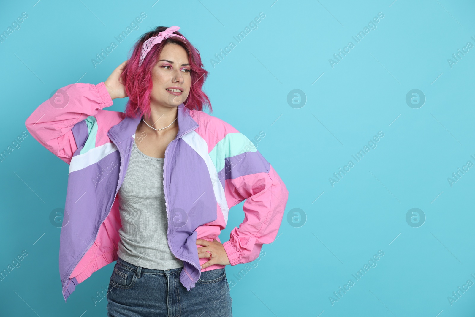 Beautiful woman with pink dyed hair on light blue background, space for text Photo of Beautiful woman with pink dyed hair on light blue background, space for text