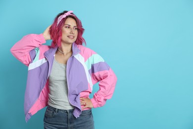 Photo of Beautiful woman with pink dyed hair on light blue background, space for text