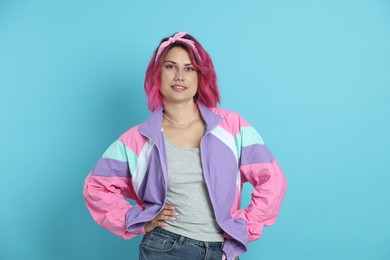 Photo of Beautiful woman with pink dyed hair on light blue background