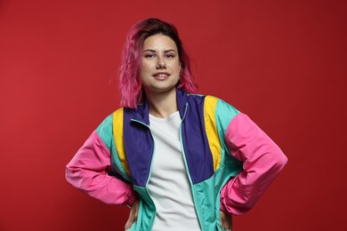 Photo of Beautiful woman with pink dyed hair on red background