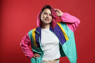 Photo of Beautiful woman with pink dyed hair on red background