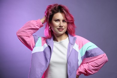 Photo of Beautiful woman with pink dyed hair on violet gradient background