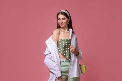 Photo of Fashionable portrait of beautiful woman in stylish outfit on pink background