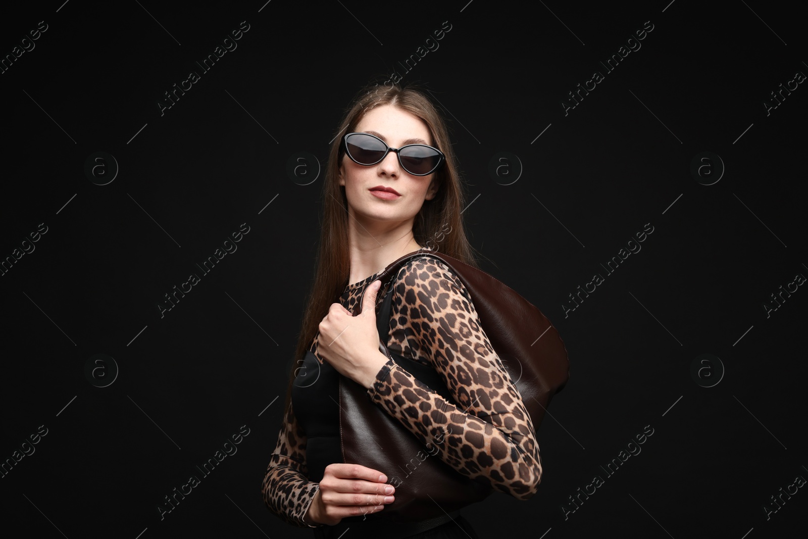 Fashionable portrait of beautiful woman in stylish outfit on black background Photo of Fashionable portrait of beautiful woman in stylish outfit on black background