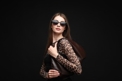 Photo of Fashionable portrait of beautiful woman in stylish outfit on black background