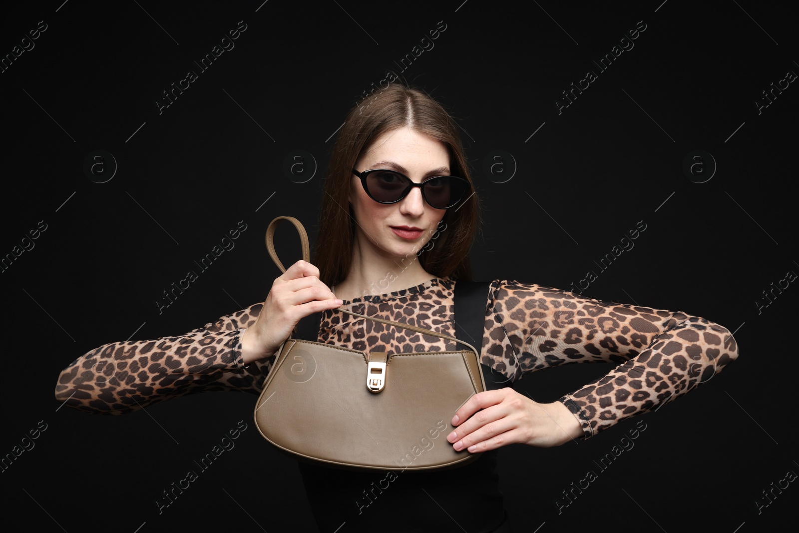 Fashionable portrait of beautiful woman in stylish outfit on black background Photo of Fashionable portrait of beautiful woman in stylish outfit on black background