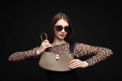 Photo of Fashionable portrait of beautiful woman in stylish outfit on black background