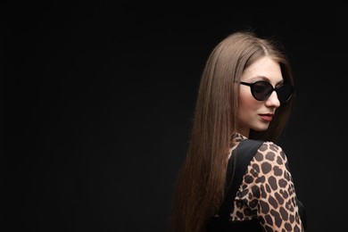 Photo of Fashionable portrait of beautiful woman in stylish outfit on black background. Space for text