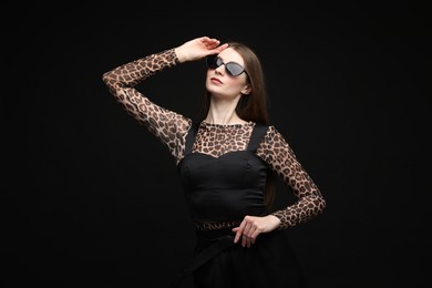 Photo of Fashionable portrait of beautiful woman in stylish outfit on black background