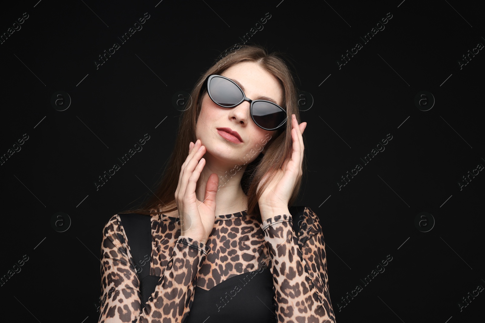 Fashionable portrait of beautiful woman in stylish outfit on black background Photo of Fashionable portrait of beautiful woman in stylish outfit on black background