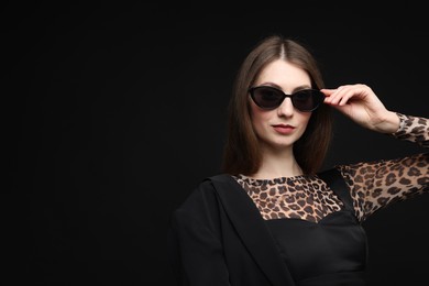 Photo of Fashionable portrait of beautiful woman in stylish outfit on black background. Space for text