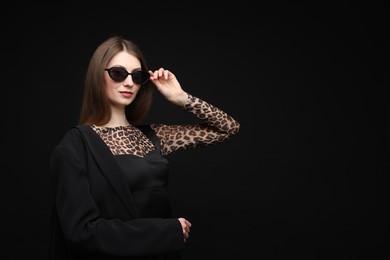 Photo of Fashionable portrait of beautiful woman in stylish outfit on black background. Space for text