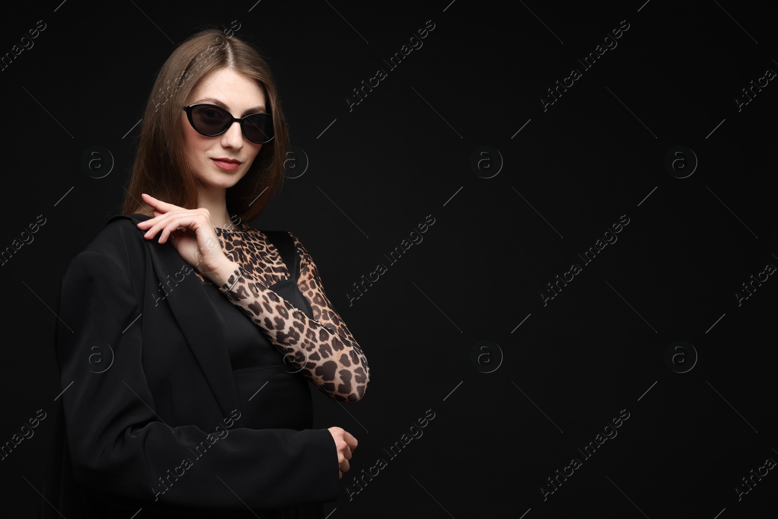 Fashionable portrait of beautiful woman in stylish outfit on black background. Space for text Photo of Fashionable portrait of beautiful woman in stylish outfit on black background. Space for text