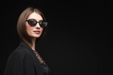 Photo of Fashionable portrait of beautiful woman in stylish outfit on black background. Space for text