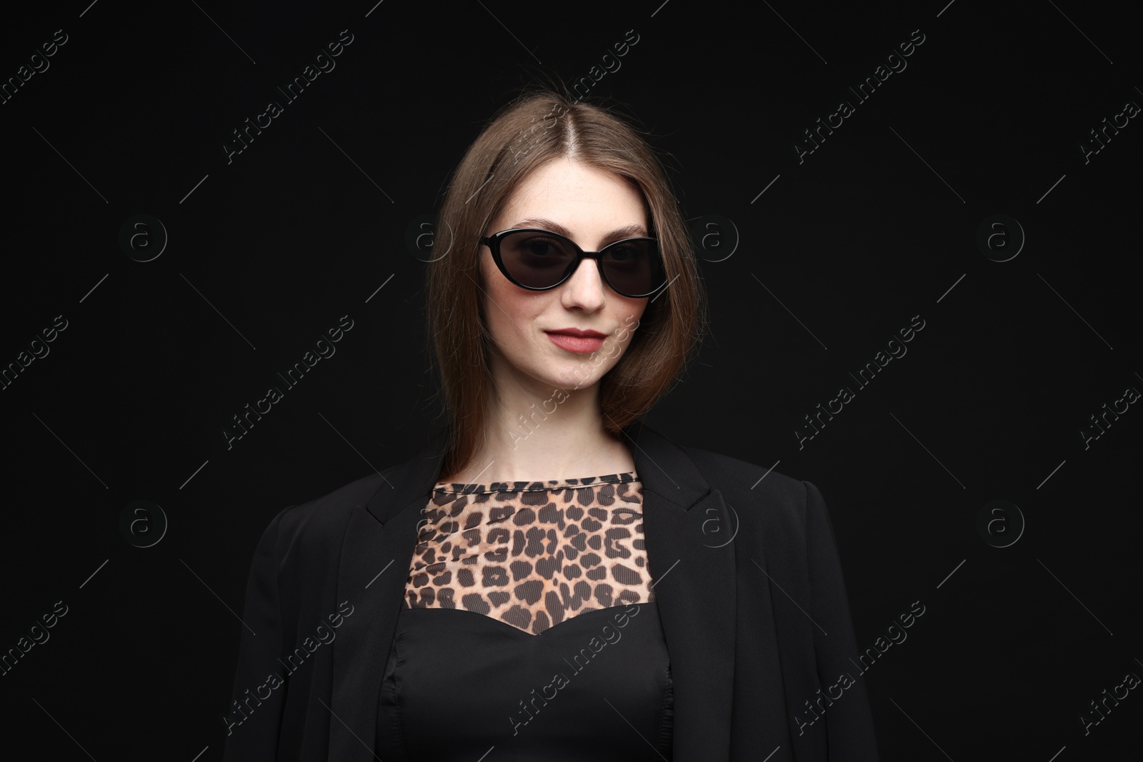 Fashionable portrait of beautiful woman in stylish outfit on black background Photo of Fashionable portrait of beautiful woman in stylish outfit on black background