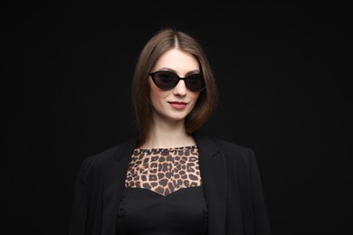 Photo of Fashionable portrait of beautiful woman in stylish outfit on black background