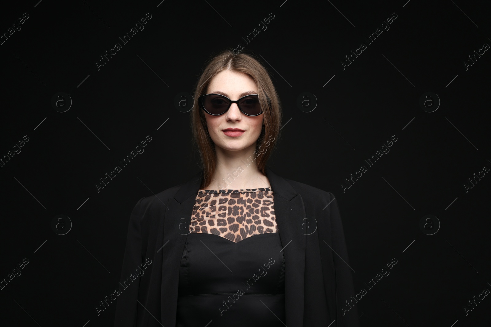 Fashionable portrait of beautiful woman in stylish outfit on black background Photo of Fashionable portrait of beautiful woman in stylish outfit on black background