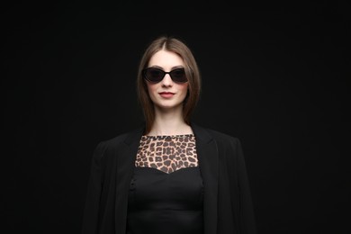 Photo of Fashionable portrait of beautiful woman in stylish outfit on black background