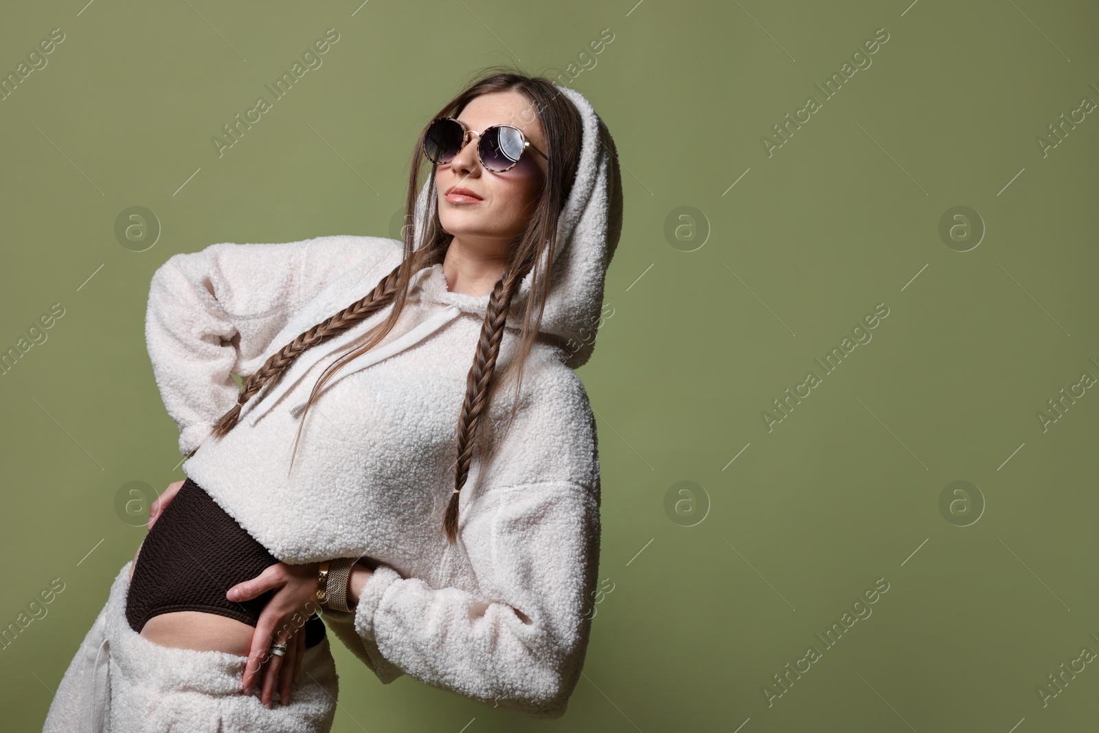 Fashionable portrait of beautiful woman in stylish outfit on green background Photo of Fashionable portrait of beautiful woman in stylish outfit on green background