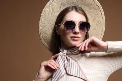 Photo of Fashionable portrait of beautiful woman in stylish outfit on brown background