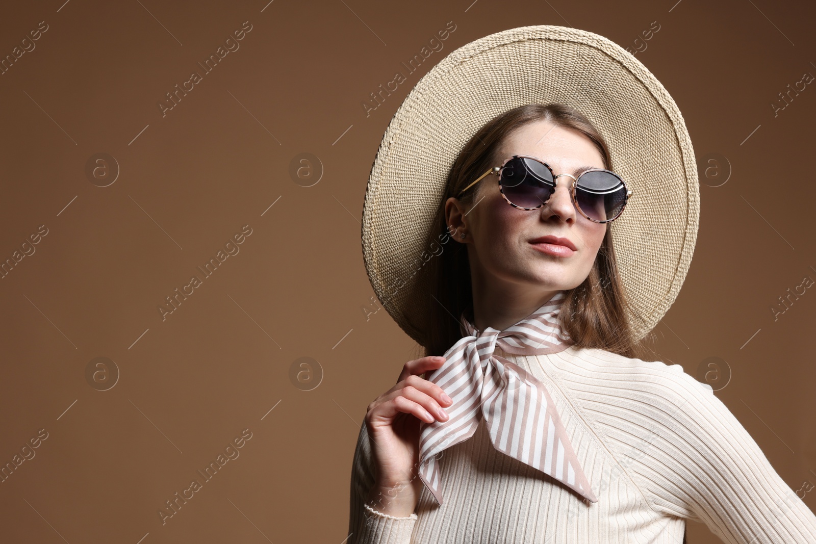 Fashionable portrait of beautiful woman in stylish outfit on brown background. Space for text Photo of Fashionable portrait of beautiful woman in stylish outfit on brown background. Space for text